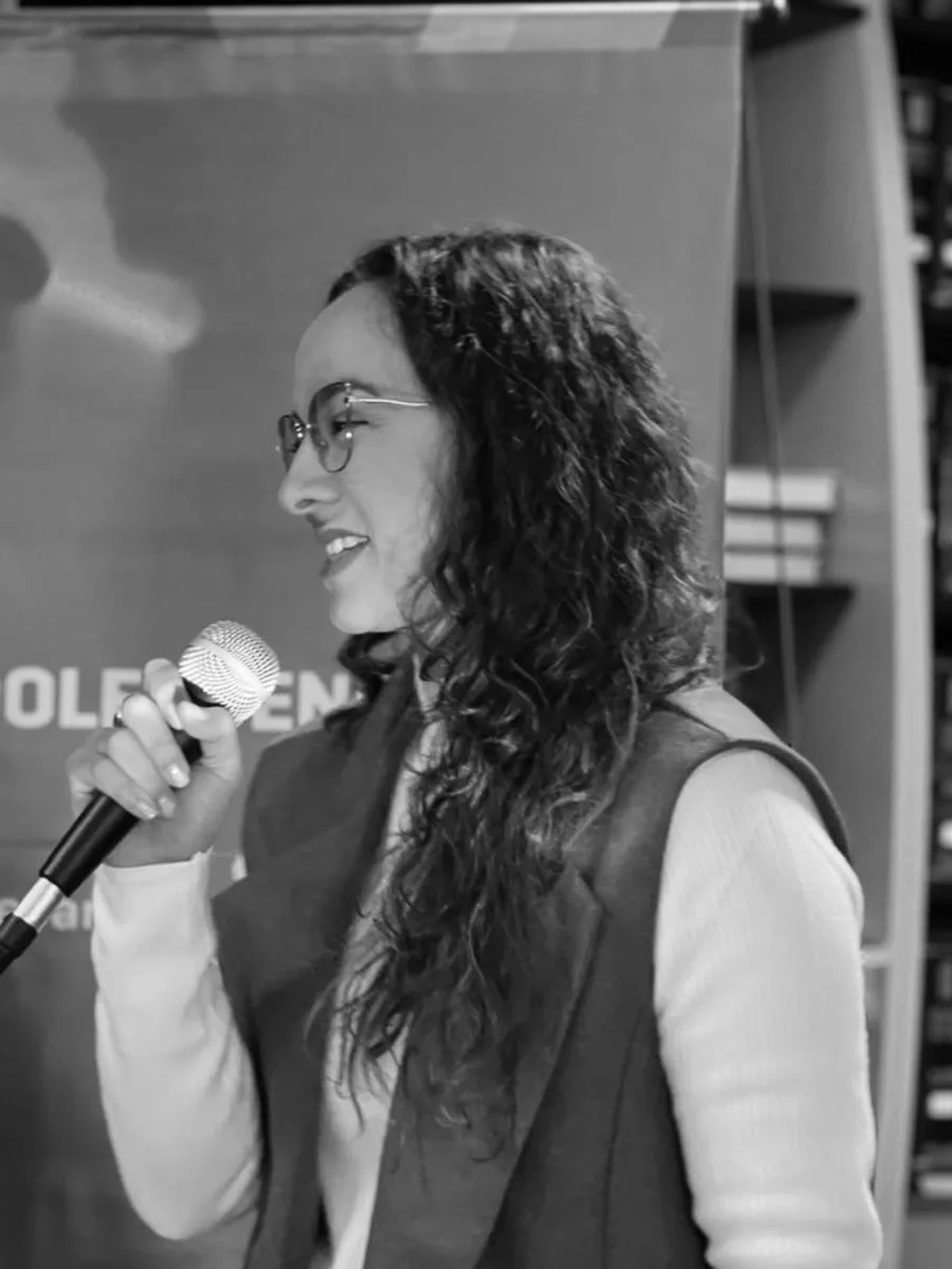 Ab. Diamela Belén Cravero hablando ante el banner de la Secretaría de Niñez, Adolescencia y Familia de la Provincia de Córdoba